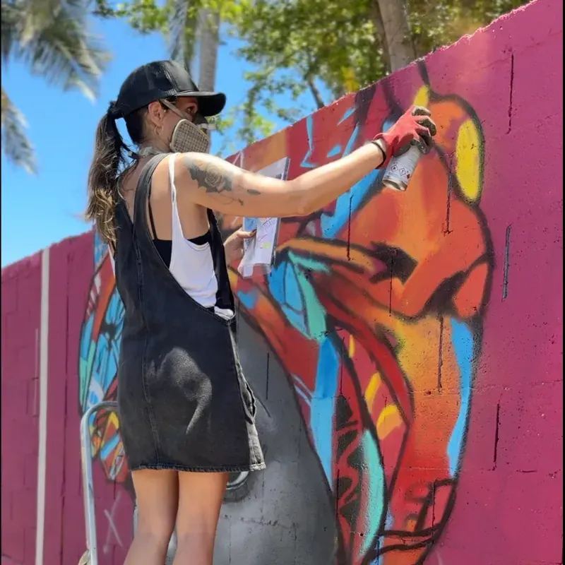 Lisa Trema, artiste graffeuse en pleine création d'une fresque murale à La Réunion