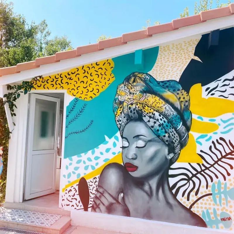 Peinture murale tropicale à La Réunion - portrait de femme au turban devant case créole